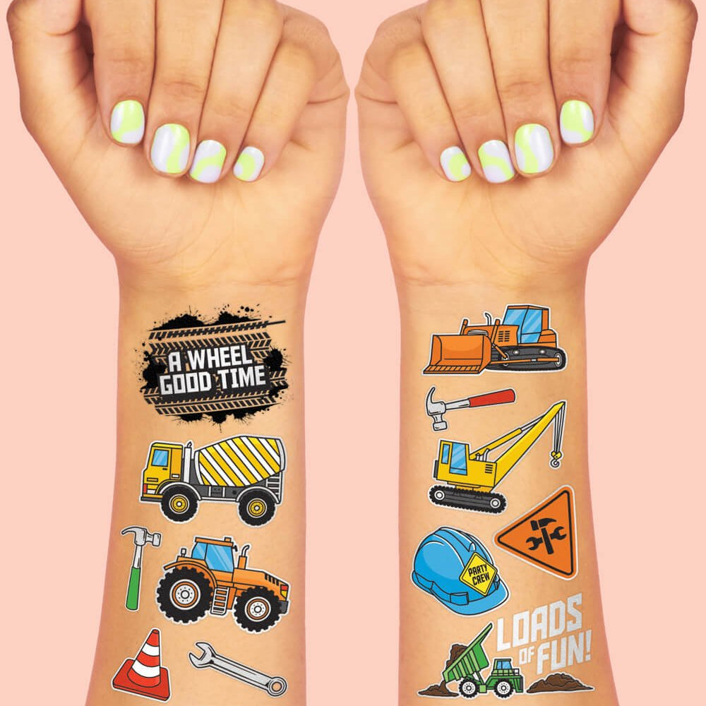 Construction temporary tattoos on two wrists showing a dump truck, digger, and road sign art