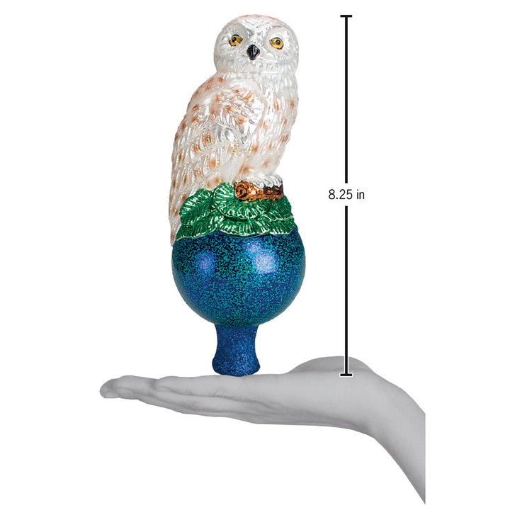 Snowy owl tree topper on an open palm beside an 8.25 inch height marker