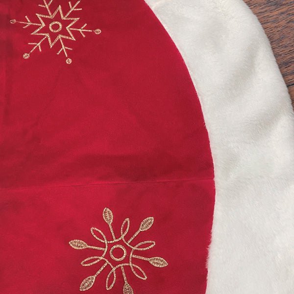Close-up of the gold snowflake embroidery on red fabric beside the white faux fur border