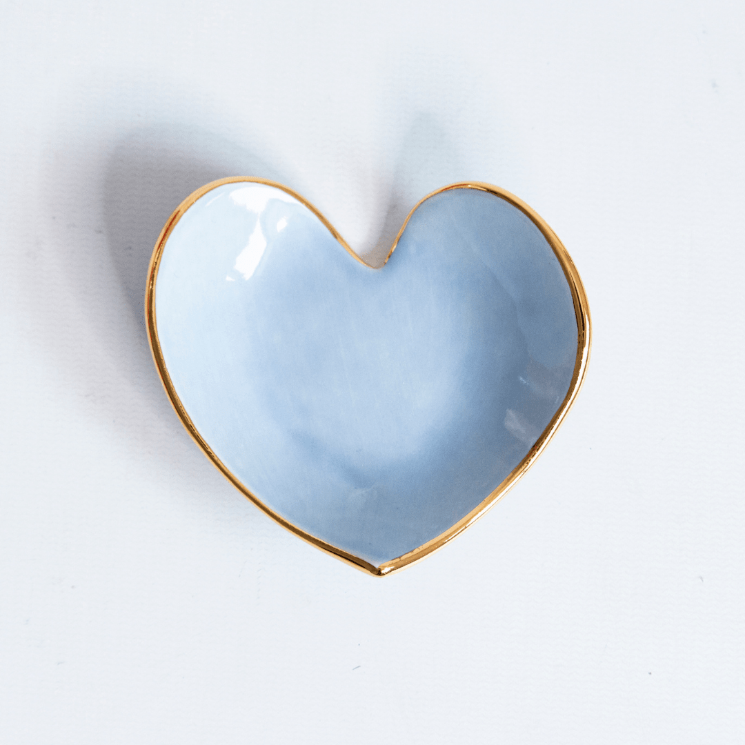 Close view of a light blue heart ring dish with a gold rim