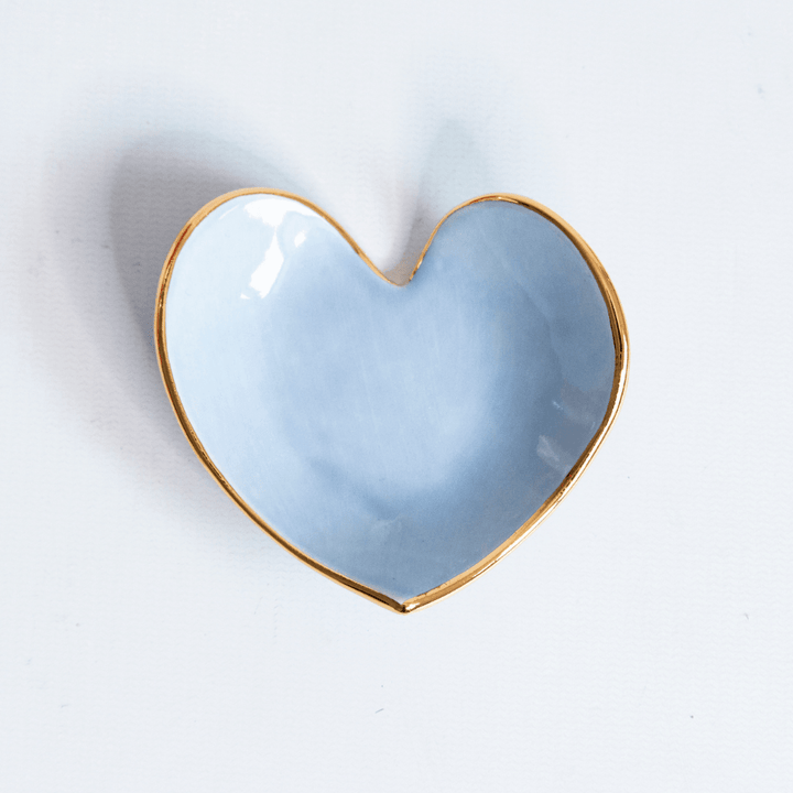 Close view of a light blue heart ring dish with a gold rim