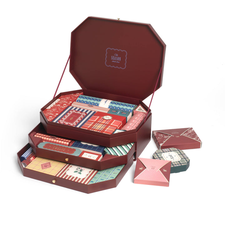 Three stacked drawers of the Papier stationery advent calendar filled with paper wrapped presents for December gifting