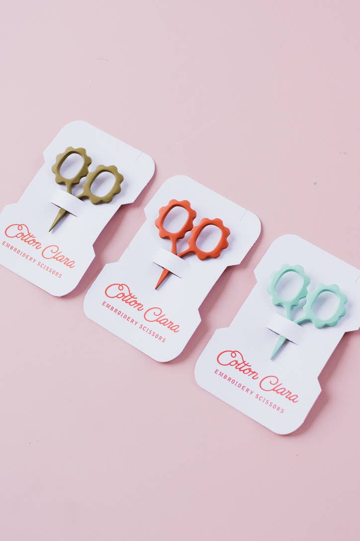 Olive, rust, and mint flower embroidery scissors cards on a pink background