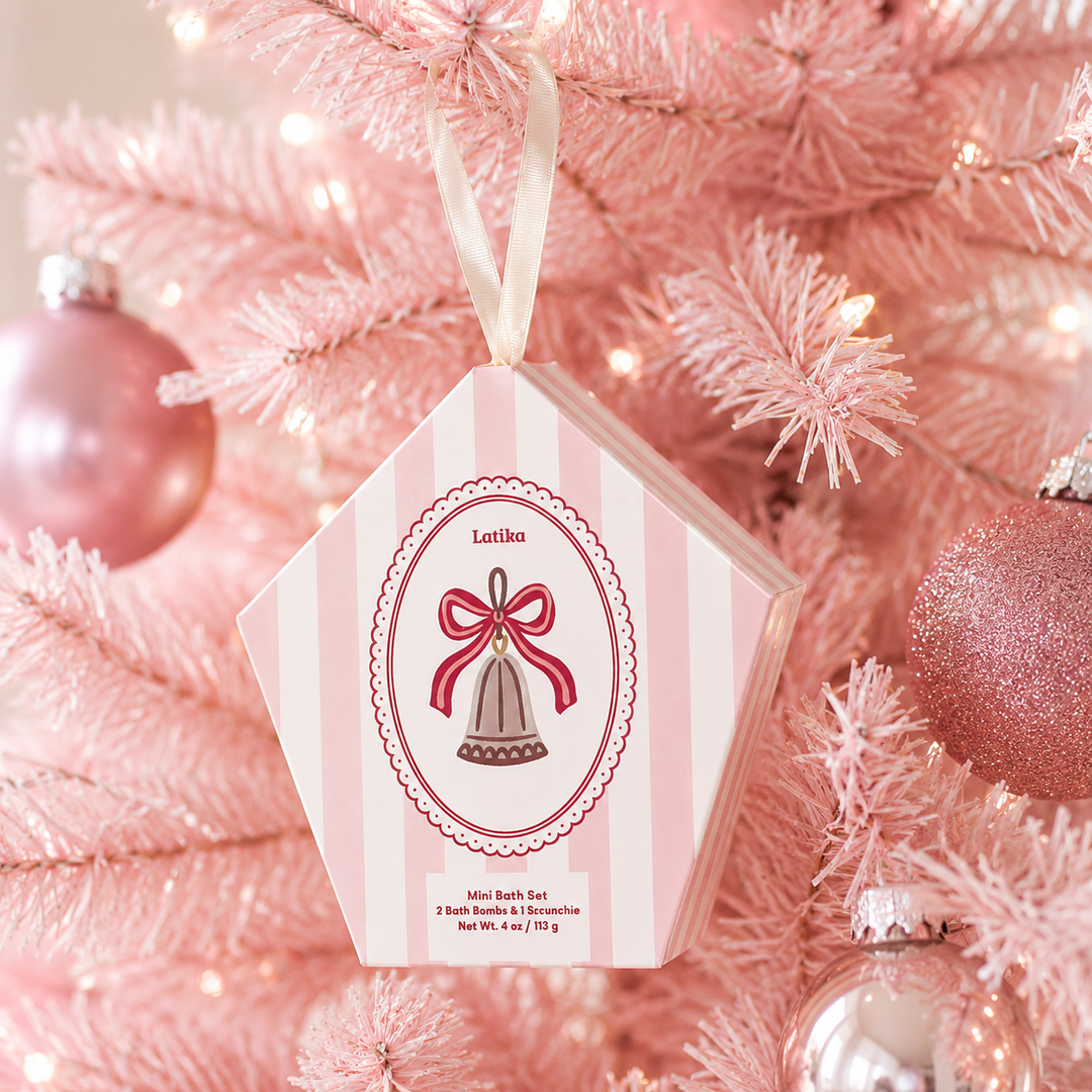 Pink striped bell box hanging on a pink flocked Christmas tree with rosy ornaments