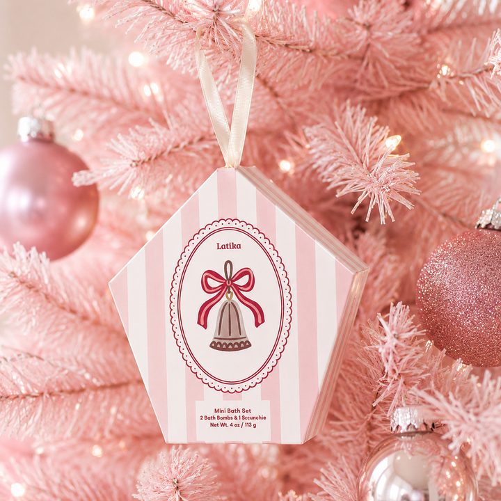 Pink striped bell box hanging on a pink flocked Christmas tree with rosy ornaments