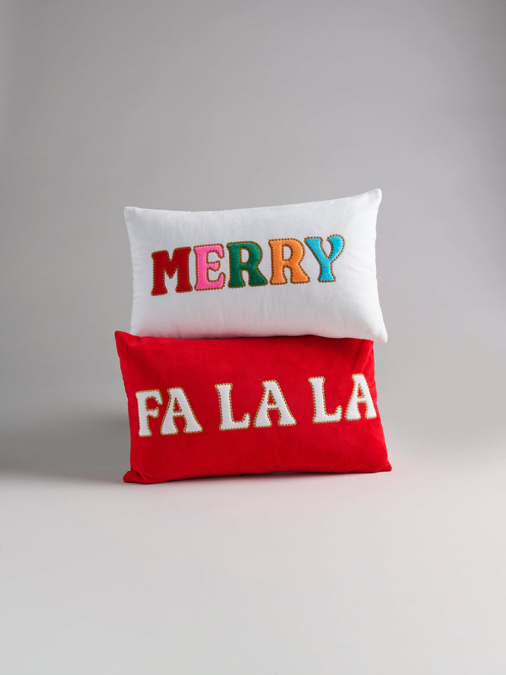 Red Fa La La pillow stacked with a white Merry pillow