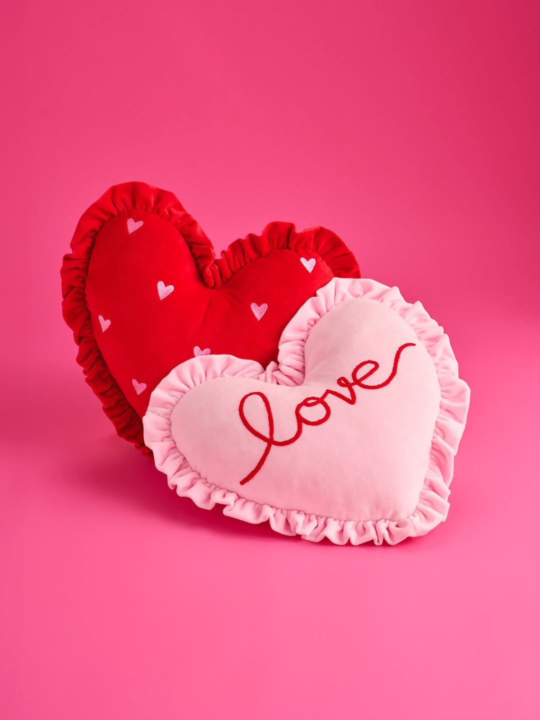 Red ruffle heart pillow with a pink Love heart pillow on pink