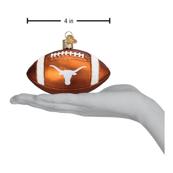 Texas football ornament on an open hand with a 4 inch width marker for scale