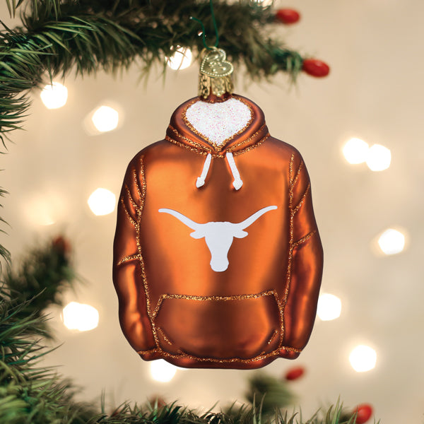Texas Longhorns hoodie Christmas ornament hanging from a pine branch against warm lights