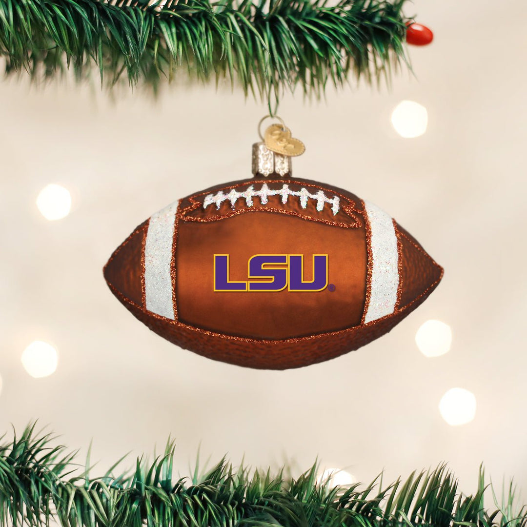 LSU football ornament hanging from a Christmas tree branch with warm golden bokeh