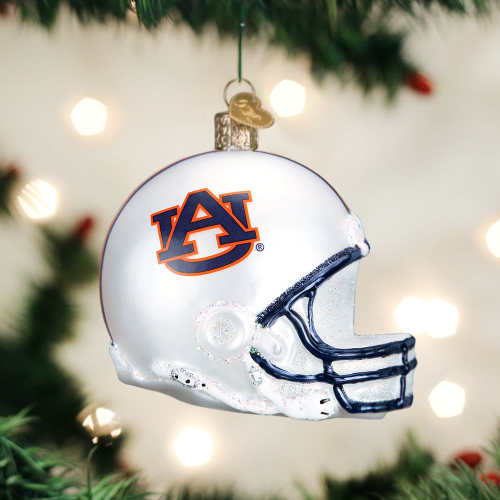 Auburn football helmet ornament hanging on a Christmas tree with blurred lights behind