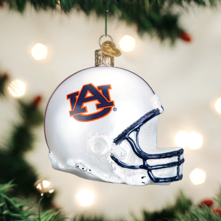 Auburn football helmet ornament hanging on a Christmas tree with blurred lights behind