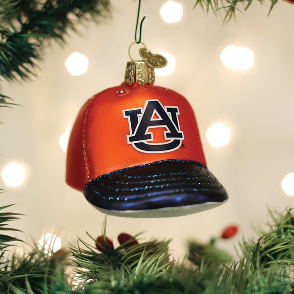 Orange Auburn Tigers cap ornament hanging on a Christmas tree with glowing bokeh lights behind