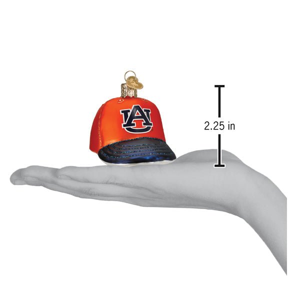 Auburn cap ornament on an open palm beside a 2.25 inch height marker for scale