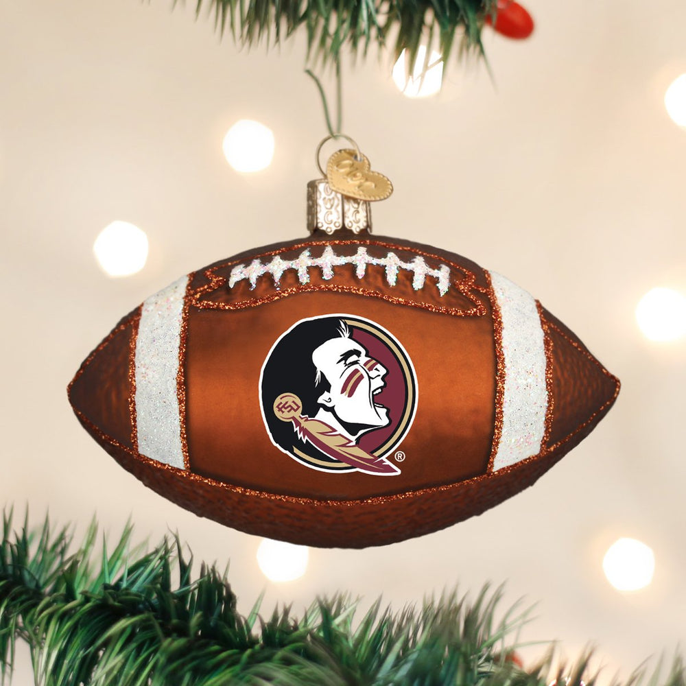 Florida State football ornament hanging from a decorated tree branch with blurred white lights