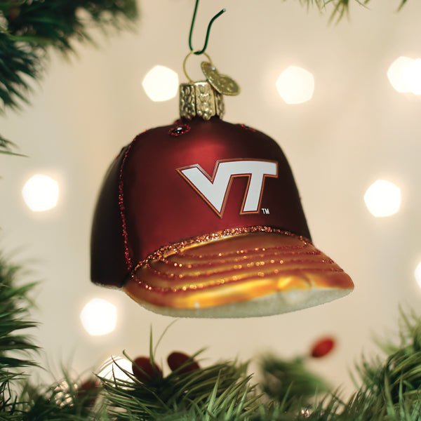 Maroon Virginia Tech Hokies cap ornament hanging on a lit Christmas tree with soft bokeh