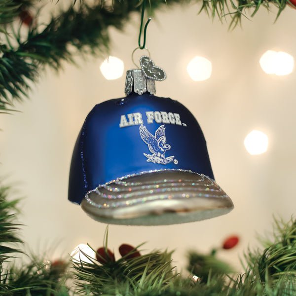 Royal blue Air Force Academy cap ornament hanging on a Christmas tree with warm twinkle lights
