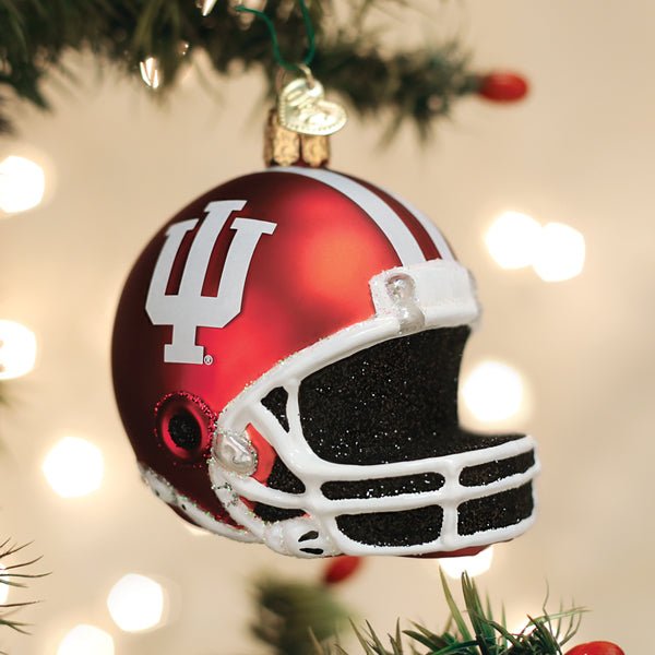 Crimson IU football helmet ornament hanging on a Christmas tree with golden twinkle lights