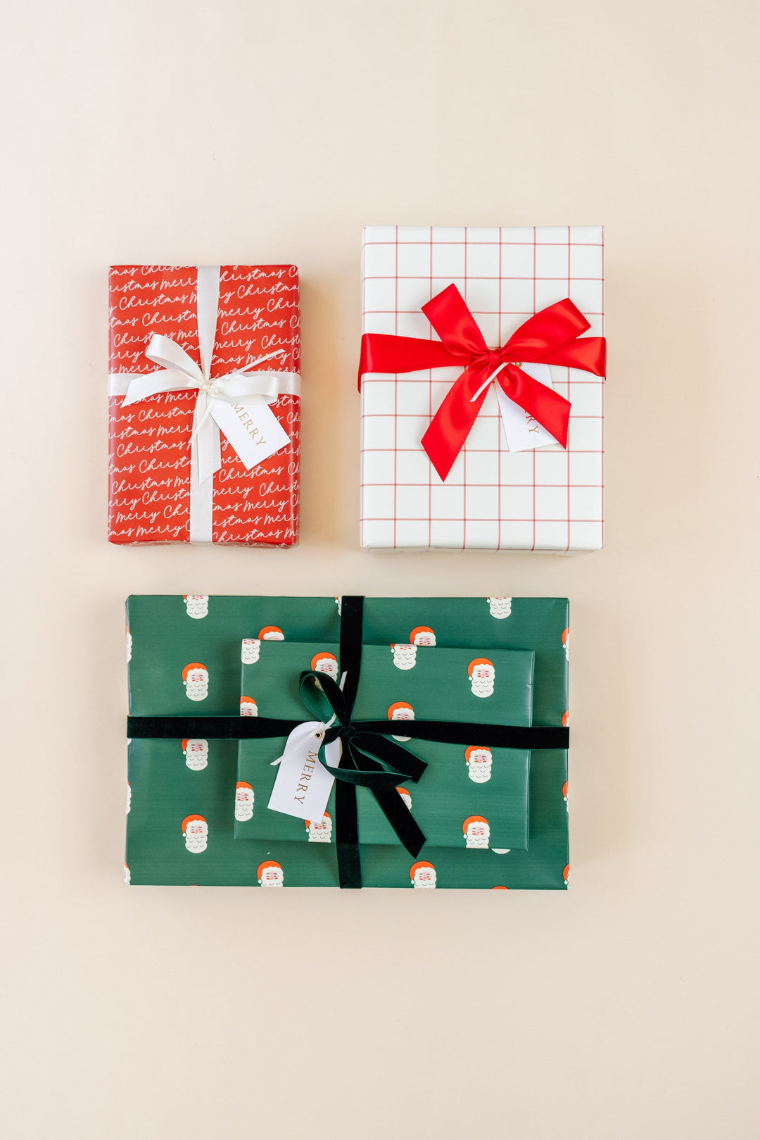 Three gifts in green Santa print, red grid on cream, and red Merry Christmas script paper on cream