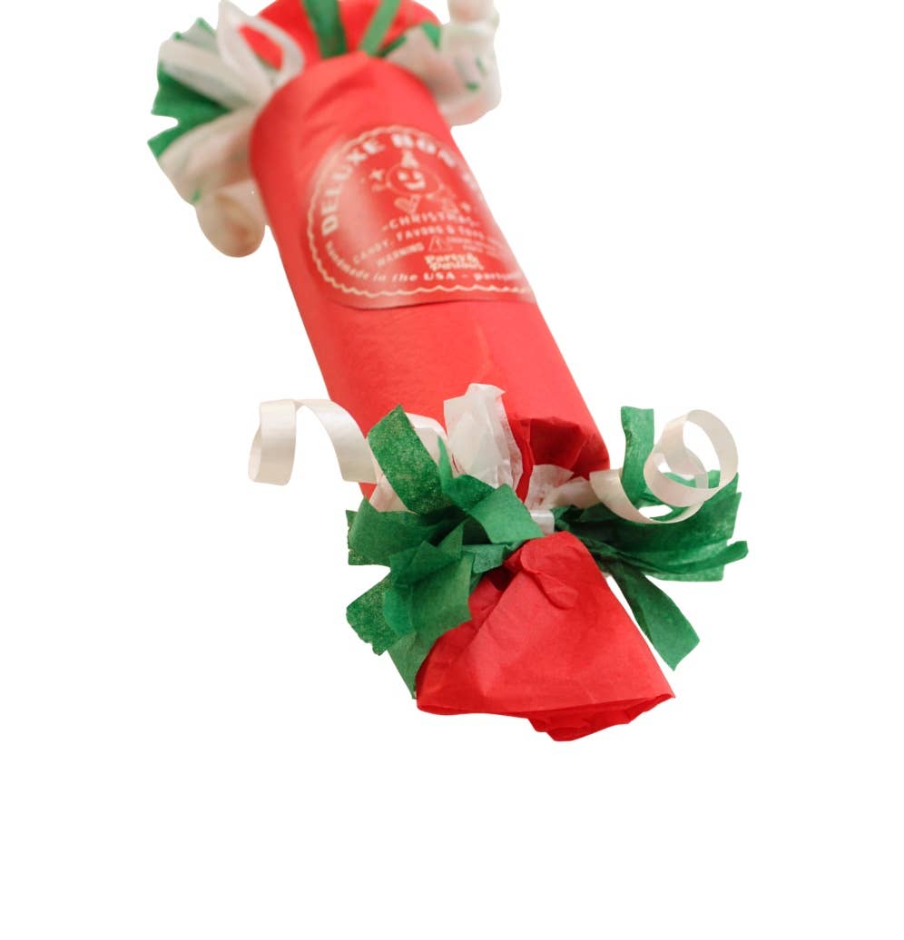 Angled close-up of the red bon bon's printed seal and green and white curled tissue fringe, a festive holiday favor