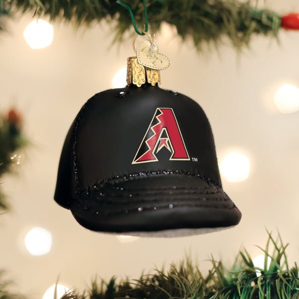 Arizona Diamondbacks cap ornament hanging on a lit Christmas tree with warm bokeh lights and pine branches