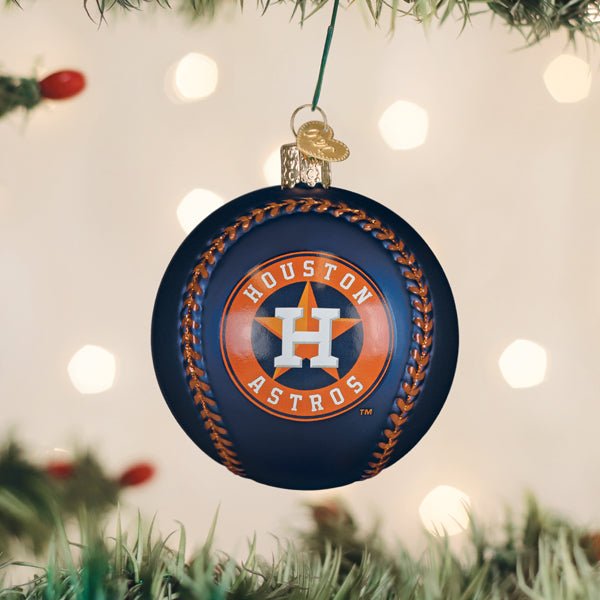 Houston Astros baseball ornament hanging on a lit Christmas tree with warm bokeh lights and pine branches