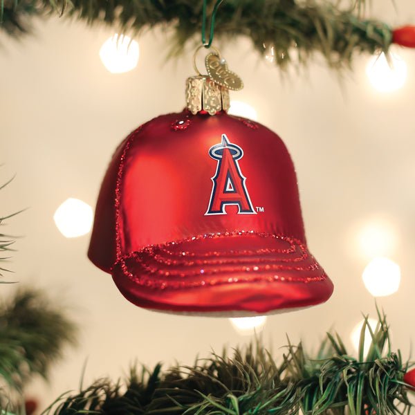 Los Angeles Angels cap ornament hanging on a lit Christmas tree with warm bokeh lights and pine branches
