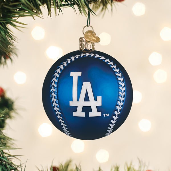 Dodgers baseball ornament hanging on a lit Christmas tree with warm bokeh lights and pine branches