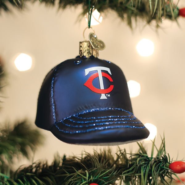 Twins cap ornament hanging on a lit Christmas tree with warm glowing bokeh lights behind
