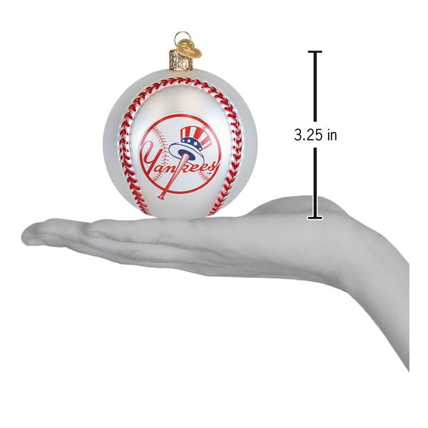 Yankees baseball ornament resting on an open palm beside a 3.25 inch height marker