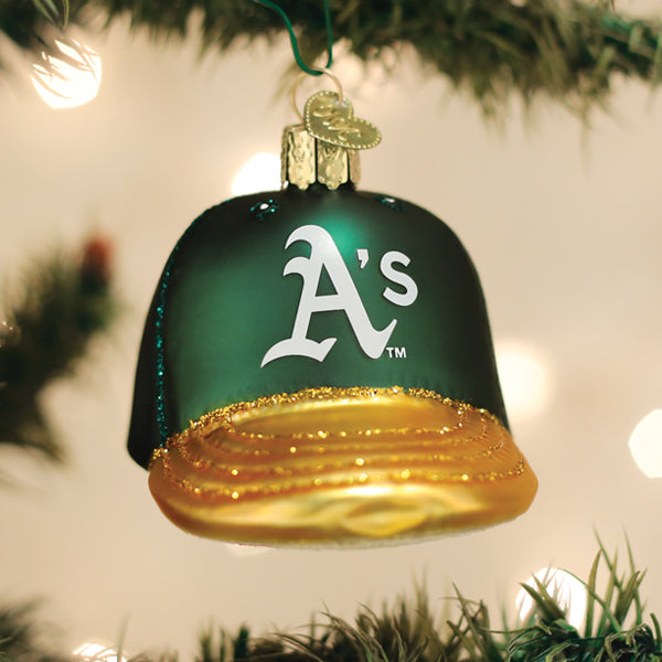 Athletics cap ornament hanging on a lit Christmas tree with warm glowing bokeh lights behind