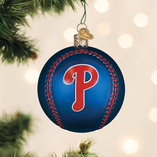 Philadelphia Phillies baseball ornament hanging on a lit Christmas tree with warm bokeh lights and pine branches