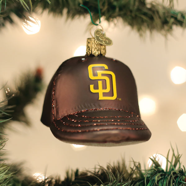 Padres cap ornament hanging on a lit Christmas tree with warm glowing bokeh lights behind