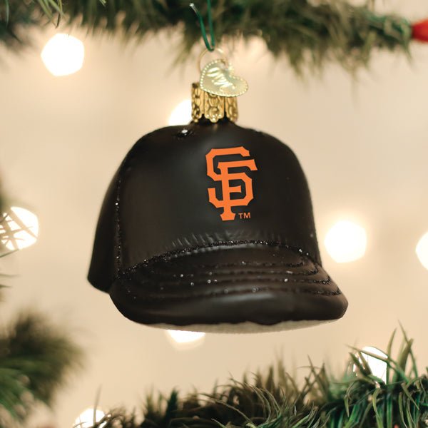 Giants cap ornament hanging on a lit Christmas tree with warm glowing bokeh lights behind