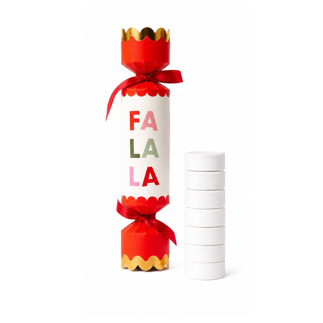 Red Fa La La Christmas cracker popper with a stack of seven white shower steamers, a fun stocking stuffer