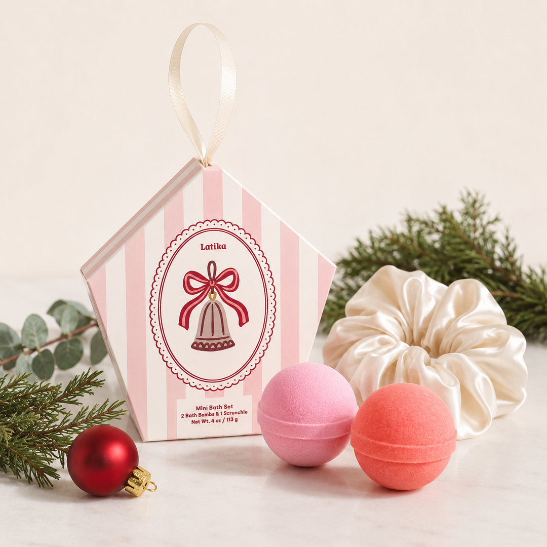 Bell mini bath set with pink and coral bath bombs, ivory scrunchie, red ornament and greenery for holiday gifting