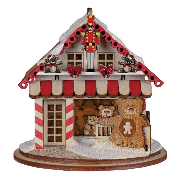 Front of the wooden teddy bear toy shop cottage with striped columns, a red awning, and bears inside, on white
