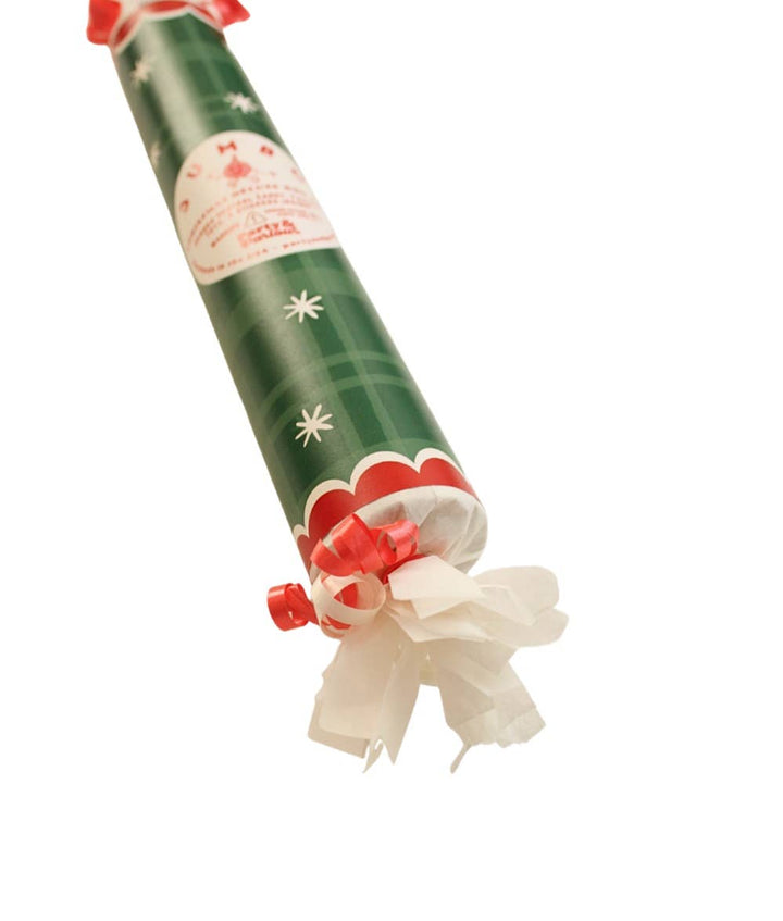 Angled close-up of the green plaid bon bon's star print, red scallop band, and curled ribbon end, a holiday favor