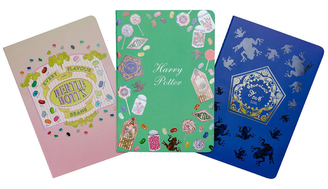 Harry Potter Honeydukes planner notebook by Insight Editions shown open to a dotted page with candy illustrations, set of three