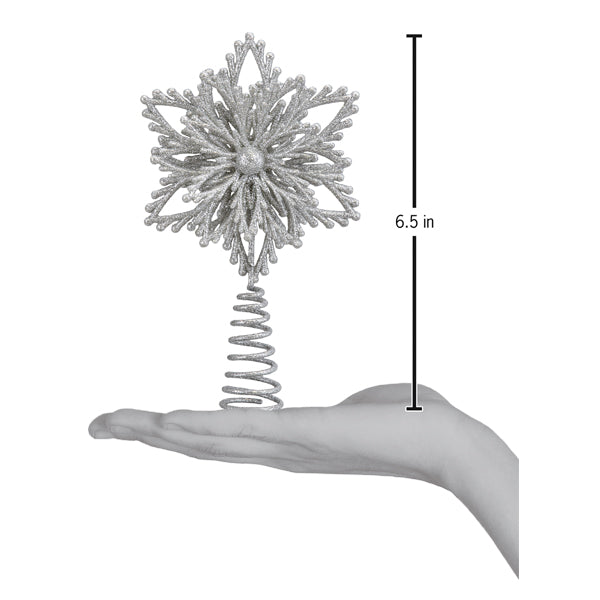 Mini snowflake tree topper on an open palm beside a 6.5 inch height marker