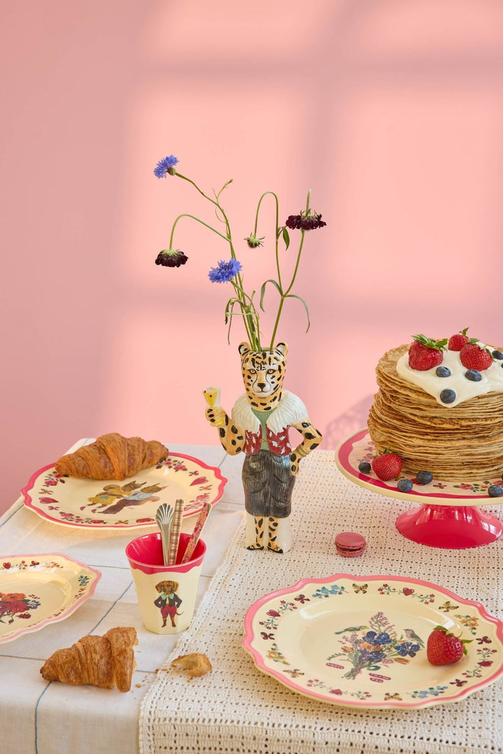 Nathalie Lété dinner plates set for brunch with pancakes, strawberries, croissants, and a leopard vase of wildflowers