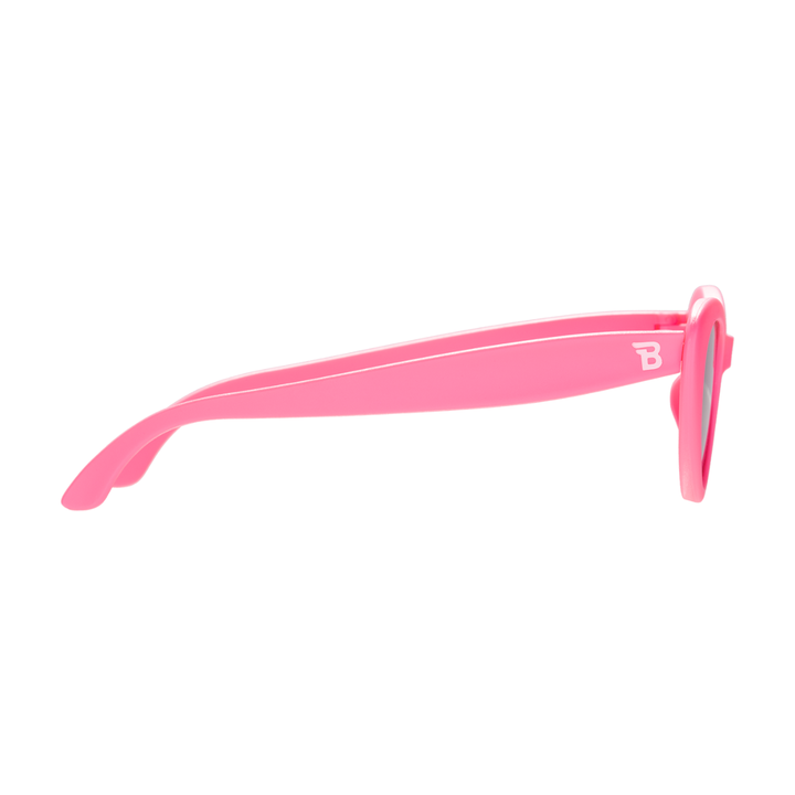 Side profile of pink cat-eye kids sunglasses showing the flexible temple arm and Babiators logo.
