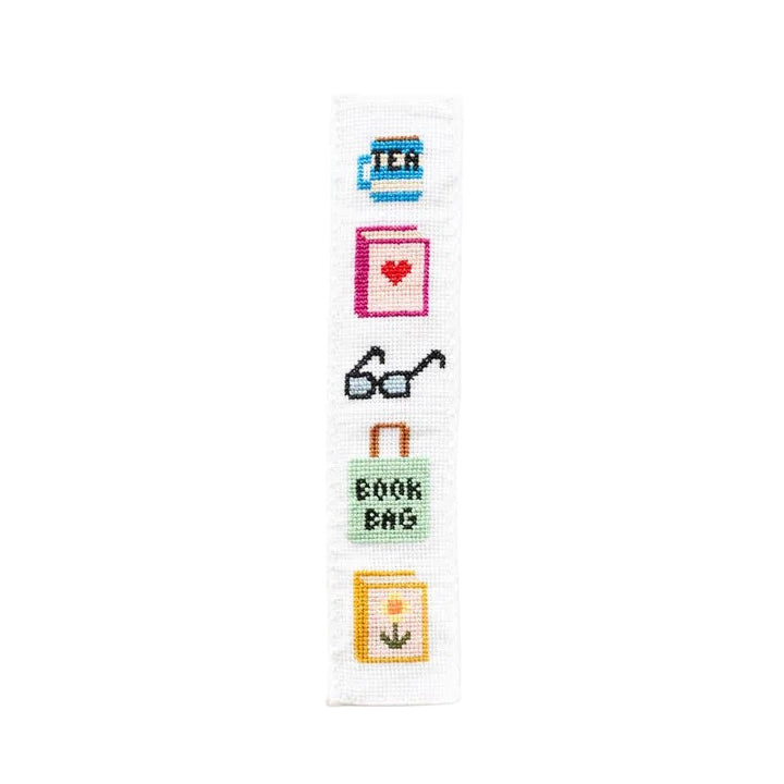 Bookish cross stitch bookmark with tea mug, heart book, glasses, and book bag motifs
