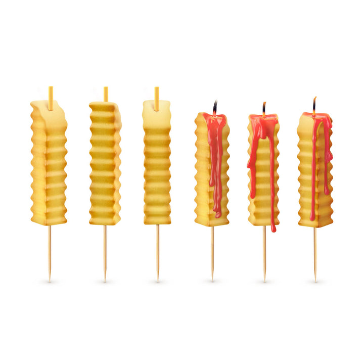 Six french fry birthday candles on white background, three unlit and three lit with red ketchup wax dripping down the sides