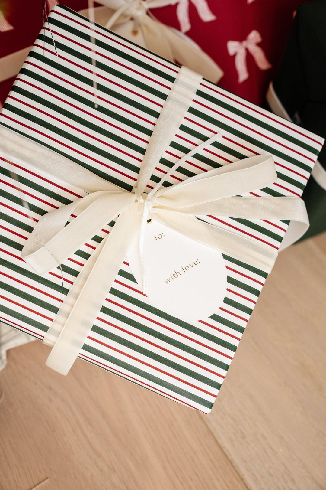 Back of an oval to and with love tag on a red and green striped present with cream ribbon