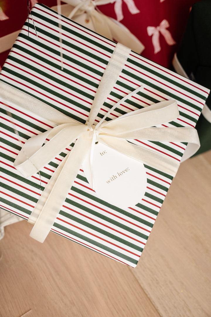 Back of an oval to and with love tag on a red and green striped present with cream ribbon