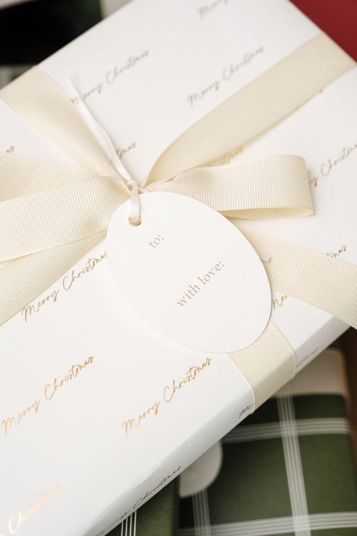Back of an oval tag reading to and with love on gold script paper with a cream bow
