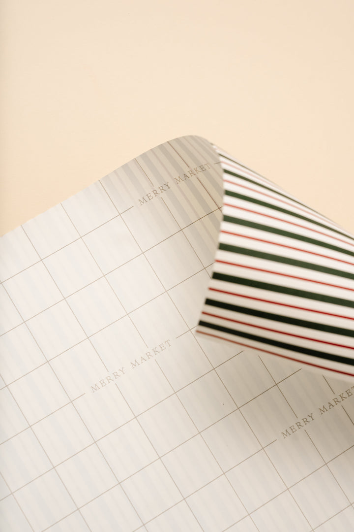 Underside of the striped Christmas wrapping paper showing printed grid lines for straight cuts