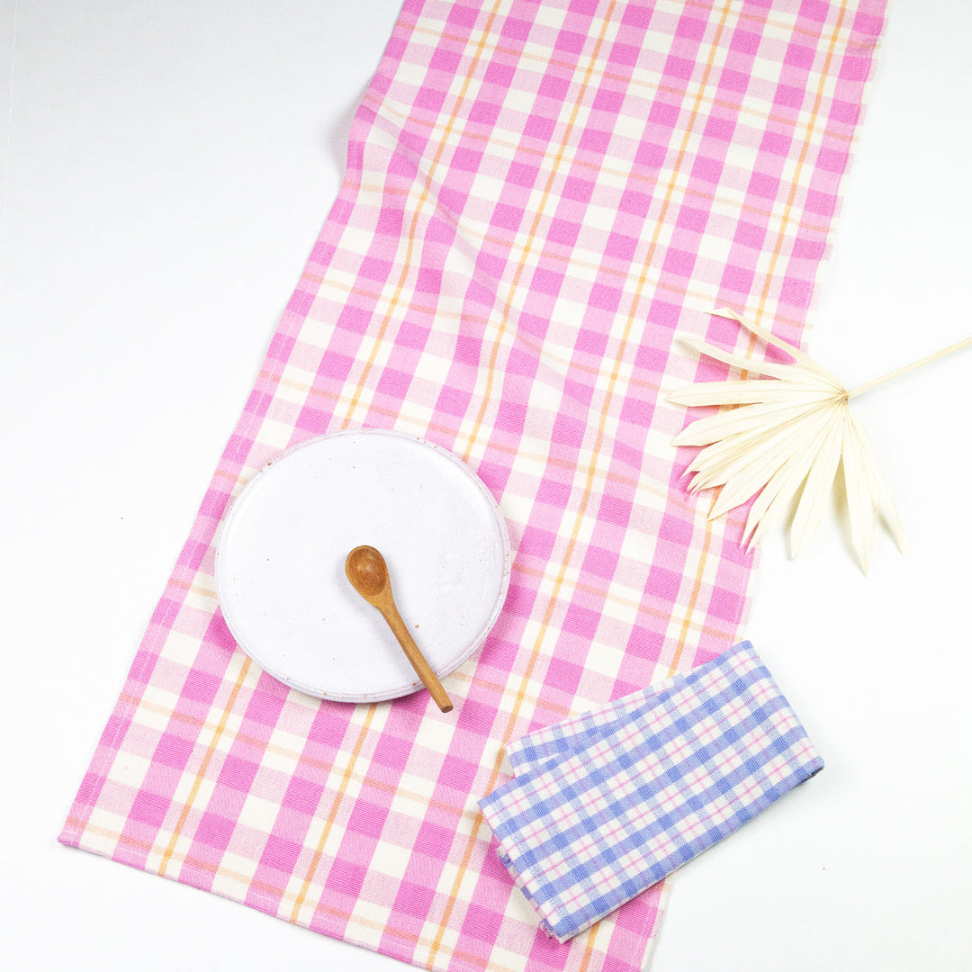 Bubblegum pink and peach plaid table runner laid across a table