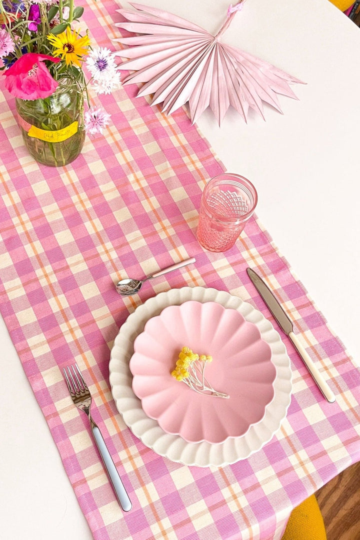 Bubblegum and peach plaid table runner styled on a tabletop for a spring gathering
